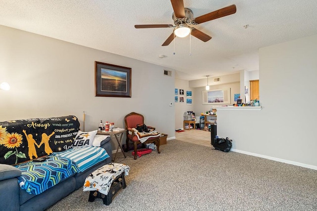 living room with a textured ceiling, light colored carpet, and ceiling fan