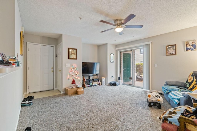 carpeted living room featuring ceiling fan and a textured ceiling