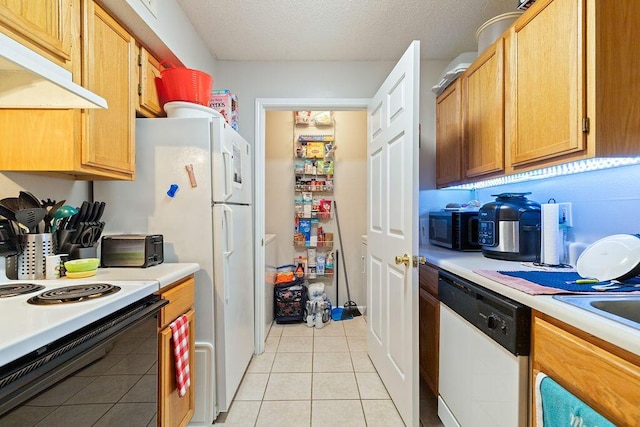 kitchen featuring a textured ceiling, light tile patterned flooring, and white appliances