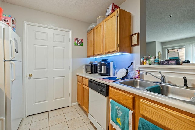 kitchen with sink, a textured ceiling, white appliances, and light tile patterned flooring