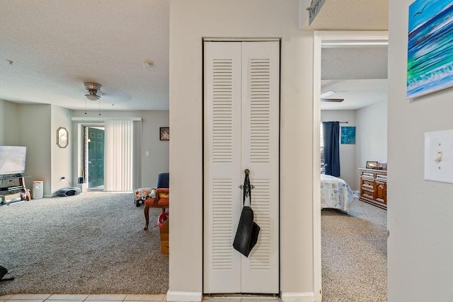 hallway featuring light carpet and a textured ceiling