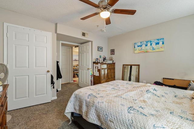 bedroom with dark colored carpet, ceiling fan, and a textured ceiling