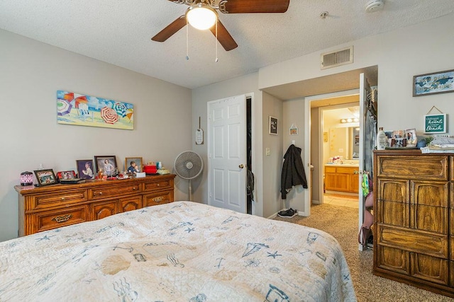 carpeted bedroom featuring a textured ceiling, connected bathroom, ceiling fan, and sink