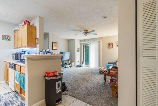 kitchen featuring white dishwasher, ceiling fan, light carpet, and a textured ceiling