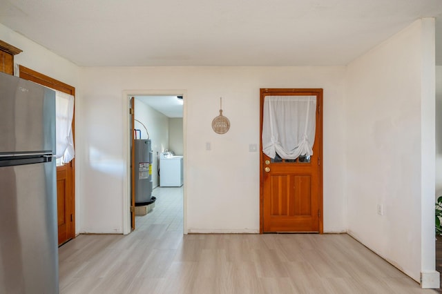 entrance foyer featuring washer / dryer, electric water heater, and light hardwood / wood-style flooring