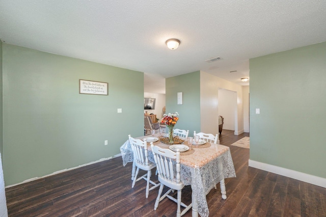 dining room featuring dark hardwood / wood-style flooring and a textured ceiling