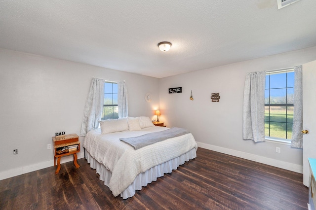 bedroom featuring a textured ceiling and dark wood-type flooring