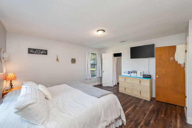 bedroom featuring a textured ceiling and dark hardwood / wood-style floors