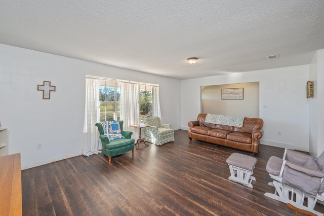 living room featuring a textured ceiling and dark hardwood / wood-style floors