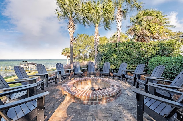 view of patio with a water view and an outdoor fire pit