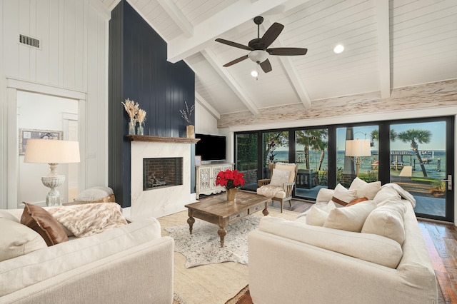 living room with hardwood / wood-style floors, vaulted ceiling with beams, ceiling fan, and a fireplace