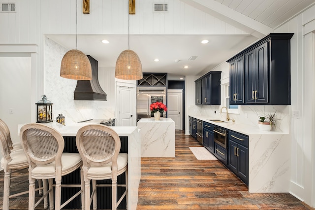 kitchen with dark wood-type flooring, blue cabinets, sink, appliances with stainless steel finishes, and tasteful backsplash