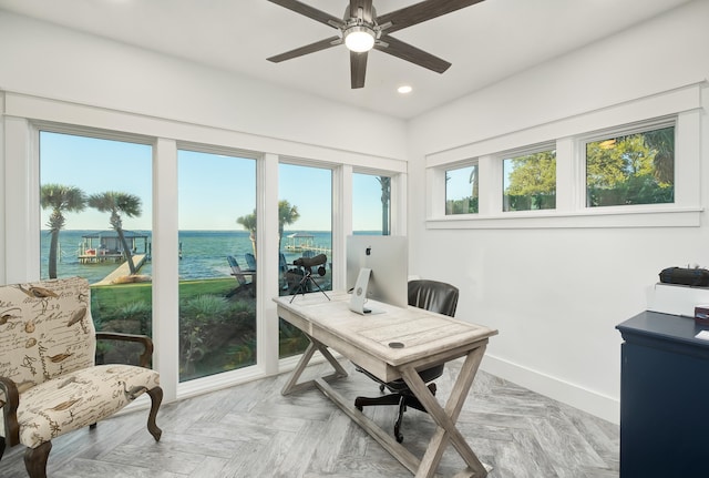 home office featuring light parquet flooring, a water view, plenty of natural light, and ceiling fan