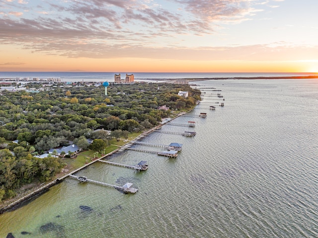 aerial view at dusk featuring a water view