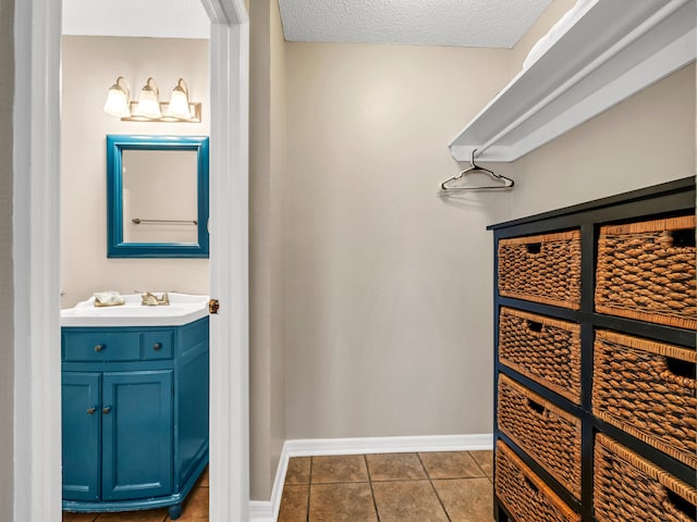 bathroom with vanity, tile patterned floors, and a textured ceiling