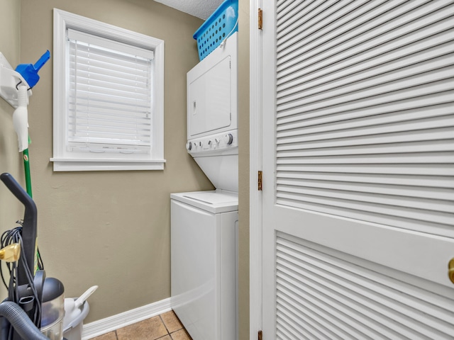 laundry room featuring stacked washer and dryer and light tile patterned floors