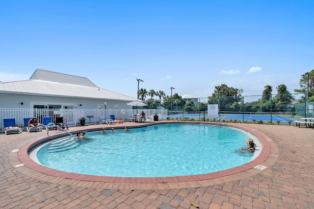 view of swimming pool featuring tennis court