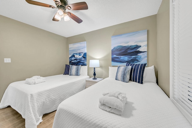 bedroom featuring ceiling fan, a textured ceiling, and light hardwood / wood-style flooring