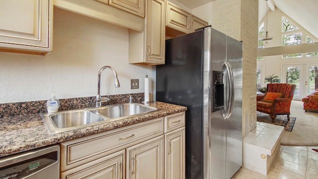 kitchen featuring lofted ceiling, french doors, cream cabinets, sink, and appliances with stainless steel finishes