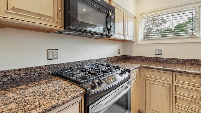 kitchen with dark stone counters and gas range