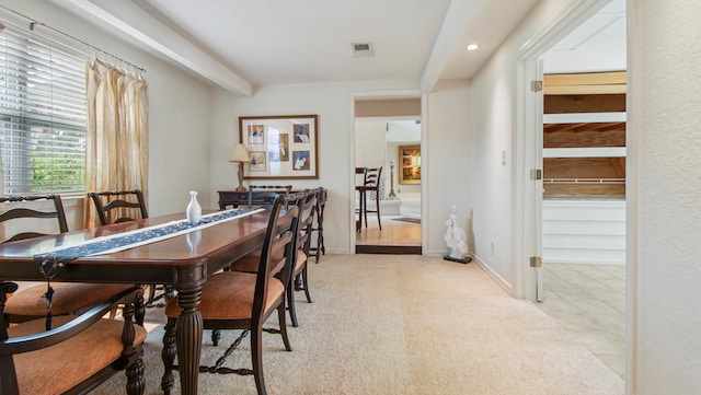 dining space with beam ceiling and light tile patterned flooring