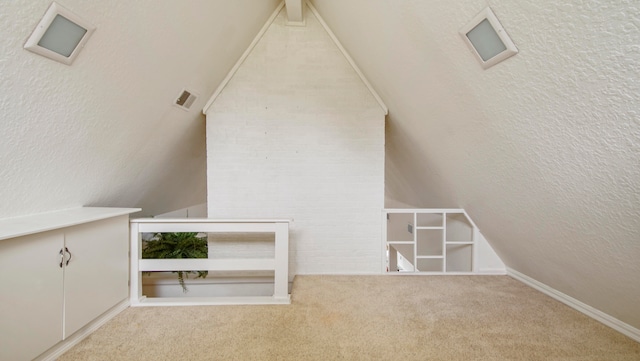 bonus room featuring a textured ceiling, light colored carpet, and vaulted ceiling