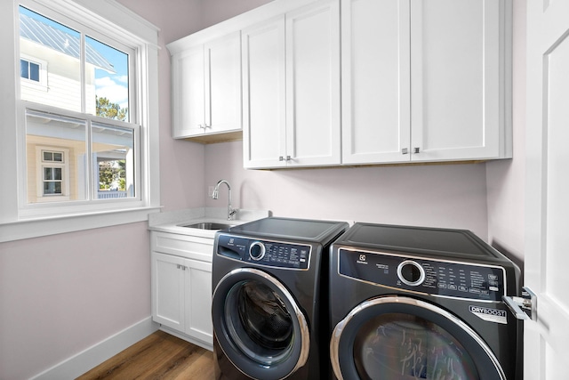 clothes washing area with cabinets, separate washer and dryer, dark wood-type flooring, and sink