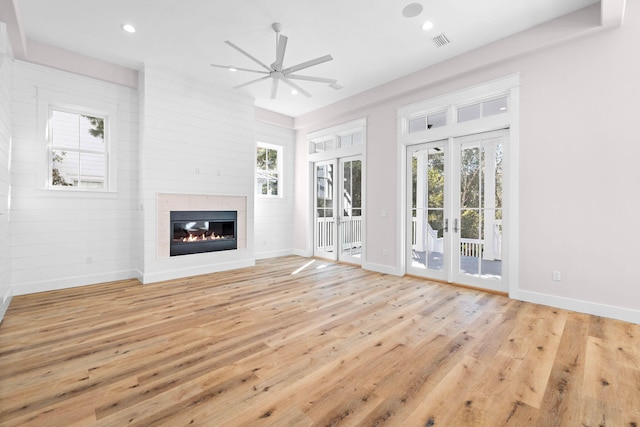 unfurnished living room featuring plenty of natural light, ceiling fan, french doors, and light hardwood / wood-style flooring