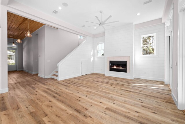 unfurnished living room featuring ceiling fan, a fireplace, and light hardwood / wood-style floors