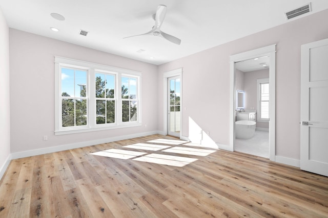 empty room with ceiling fan and light hardwood / wood-style flooring