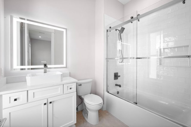 full bathroom featuring vanity, toilet, and shower / bath combination with glass door