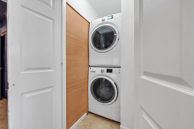 laundry room featuring stacked washer and clothes dryer and light tile patterned flooring