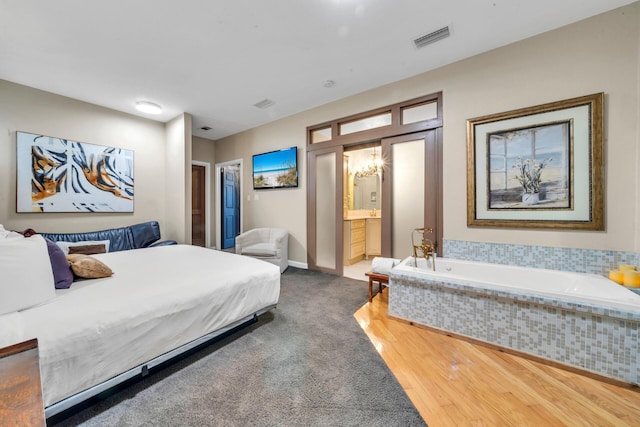 bedroom with wood-type flooring and connected bathroom