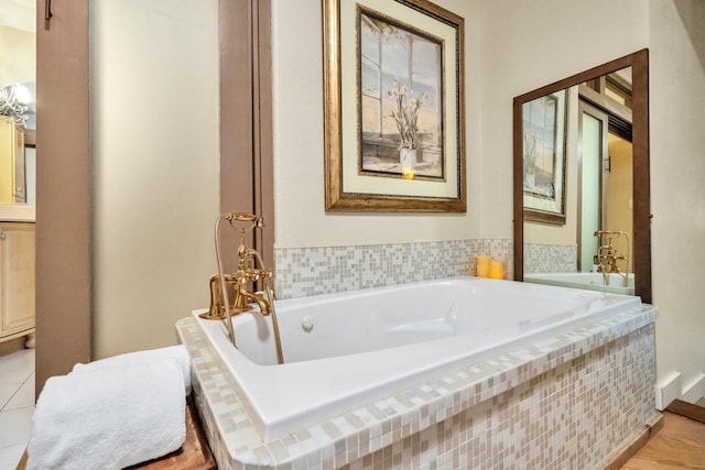 bathroom with a relaxing tiled tub and tile patterned floors