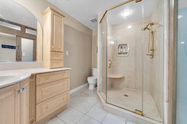 bathroom featuring tile patterned floors, vanity, toilet, and walk in shower