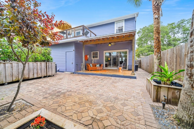 rear view of property with ceiling fan and a patio