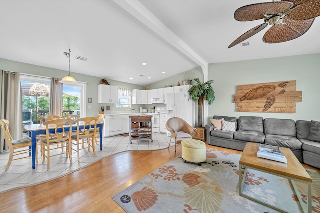 living room featuring vaulted ceiling with beams, light hardwood / wood-style floors, and ceiling fan