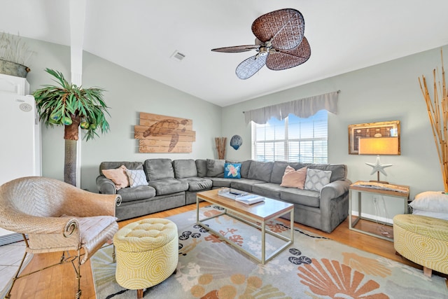 living room with ceiling fan, light hardwood / wood-style flooring, and vaulted ceiling