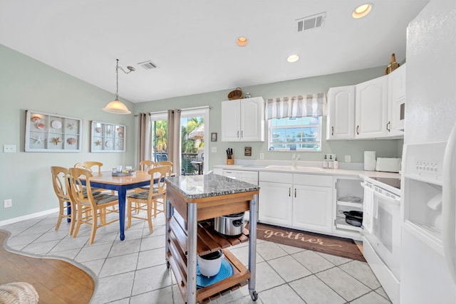 kitchen with white range oven, sink, pendant lighting, white cabinets, and light tile patterned flooring