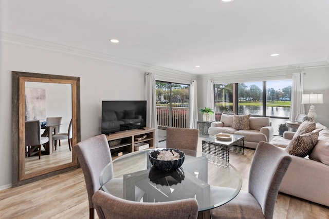 dining room featuring a wealth of natural light, light hardwood / wood-style flooring, and crown molding