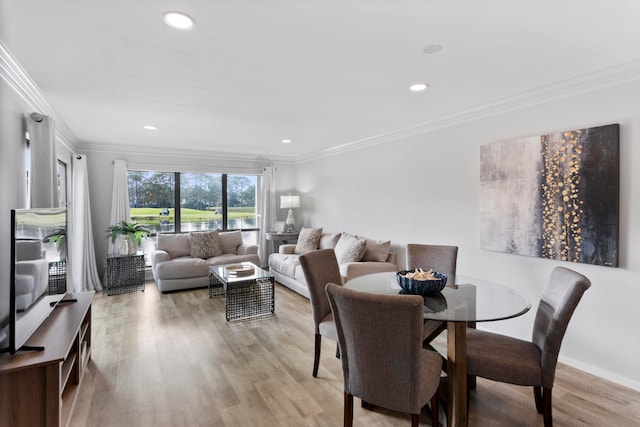 dining space with light hardwood / wood-style floors and ornamental molding