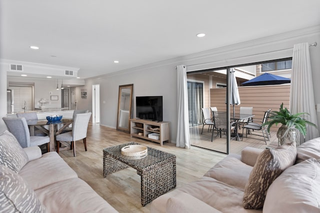 living room with ornamental molding and light hardwood / wood-style flooring