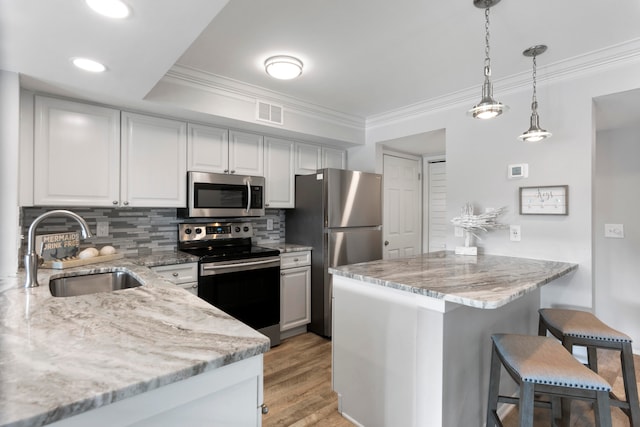 kitchen featuring ornamental molding, stainless steel appliances, sink, light hardwood / wood-style flooring, and white cabinetry