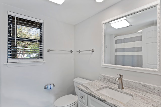 bathroom featuring a shower with curtain, vanity, and toilet