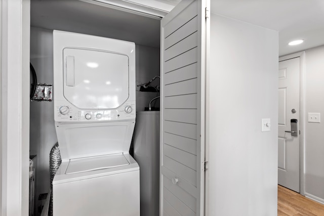 clothes washing area featuring light wood-type flooring and stacked washer / drying machine