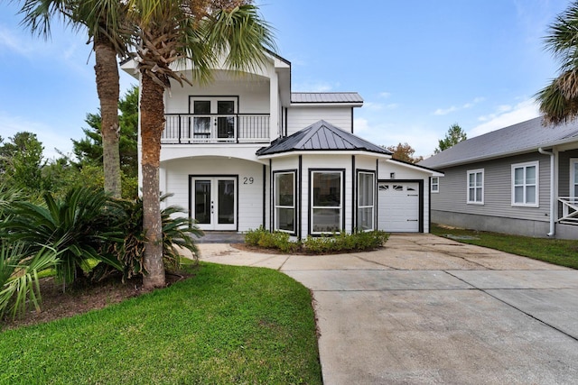 view of front facade featuring french doors, a balcony, a garage, and a front lawn