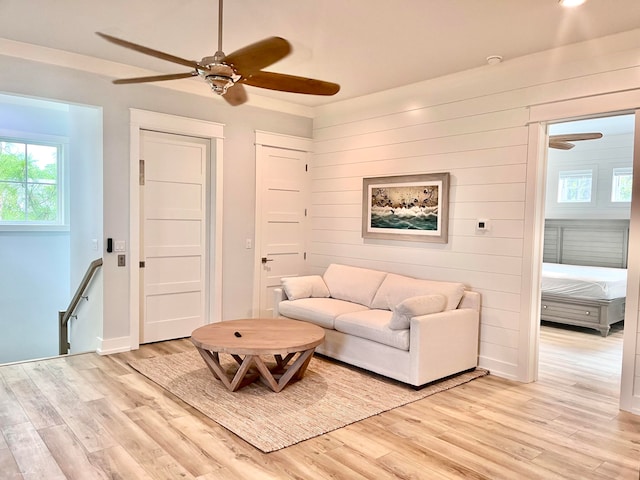 living room with light hardwood / wood-style floors and ceiling fan