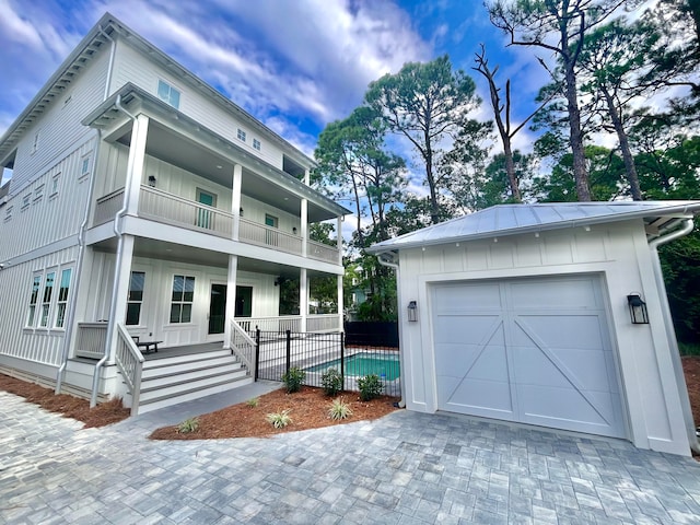 view of front of home with a porch, a balcony, and a garage