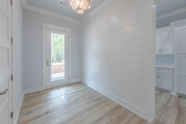 doorway to outside featuring light hardwood / wood-style flooring and ornamental molding