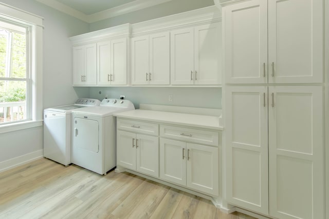 washroom featuring cabinets, light hardwood / wood-style floors, washer and dryer, and crown molding